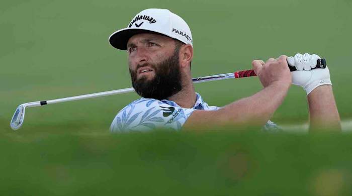 Jon Rahm from Spain plays a bunker shot on the first hole during the 2023 DP World Tour Championship golf tournament in Dubai, United Arab Emirates.